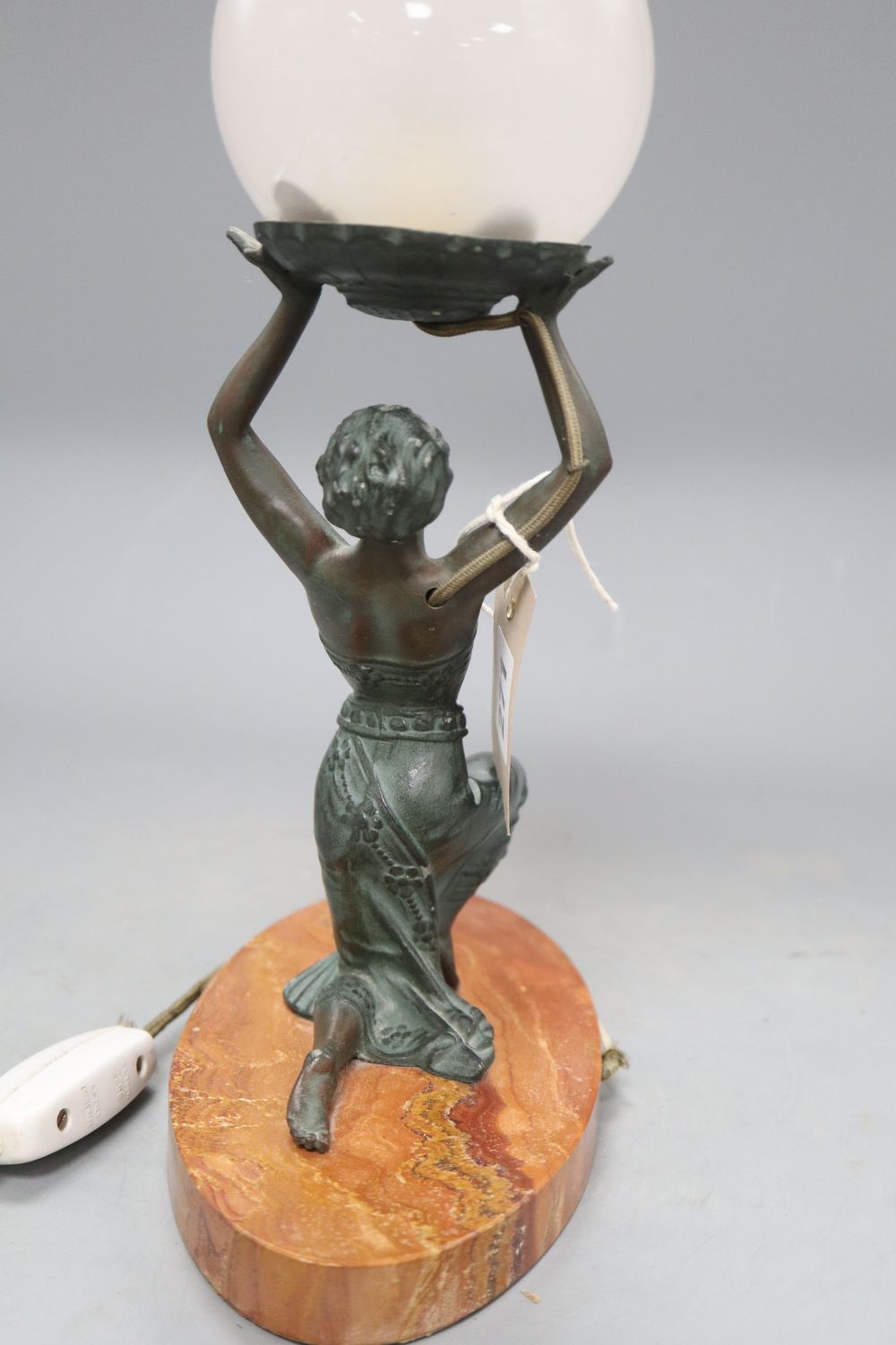 An Art Deco table lamp modelled as bronzed kneeling lady holding a globe, on oval rouge marble base, height 31.5cm